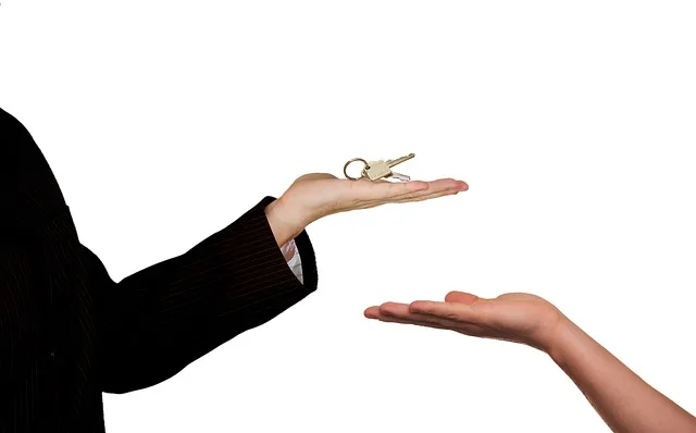 Home owner handing over house keys to selected house care taker.